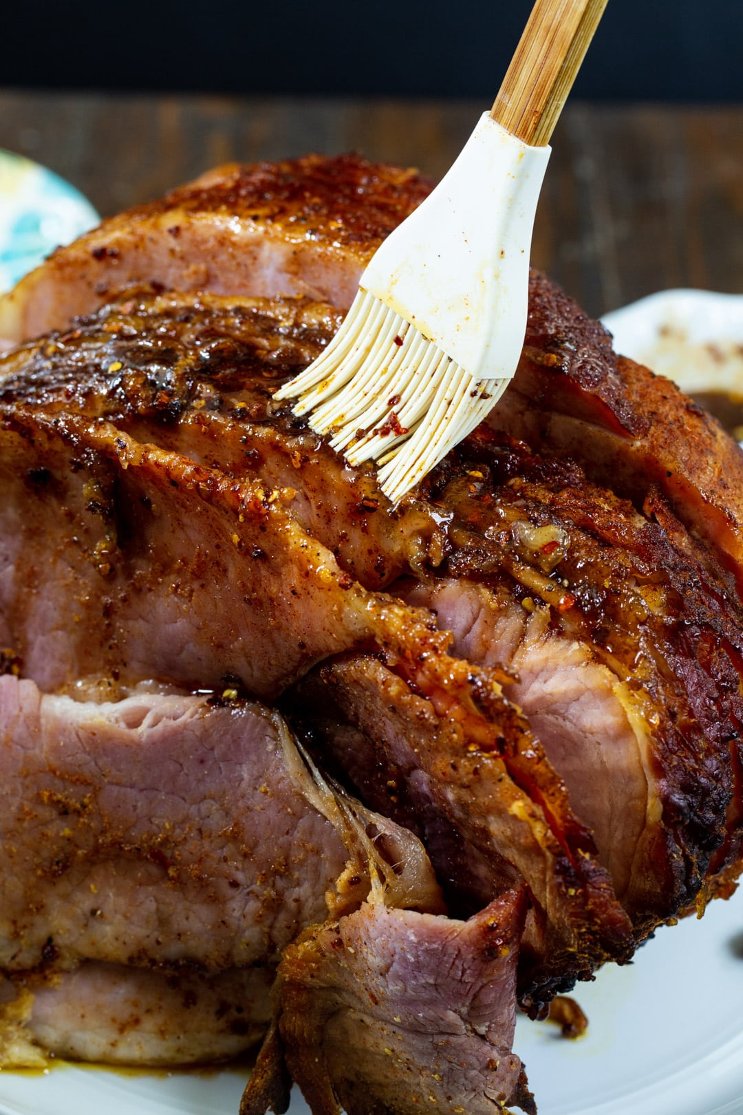 Ham being brushed with honey glaze.