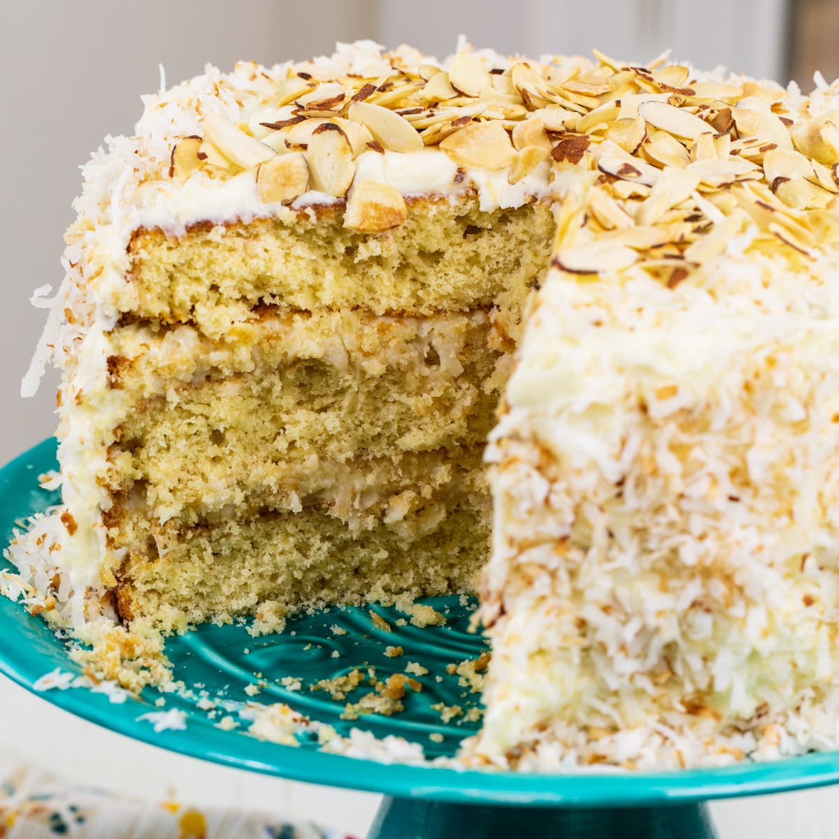 Coconut Almond Cream Cake with slice cut out.