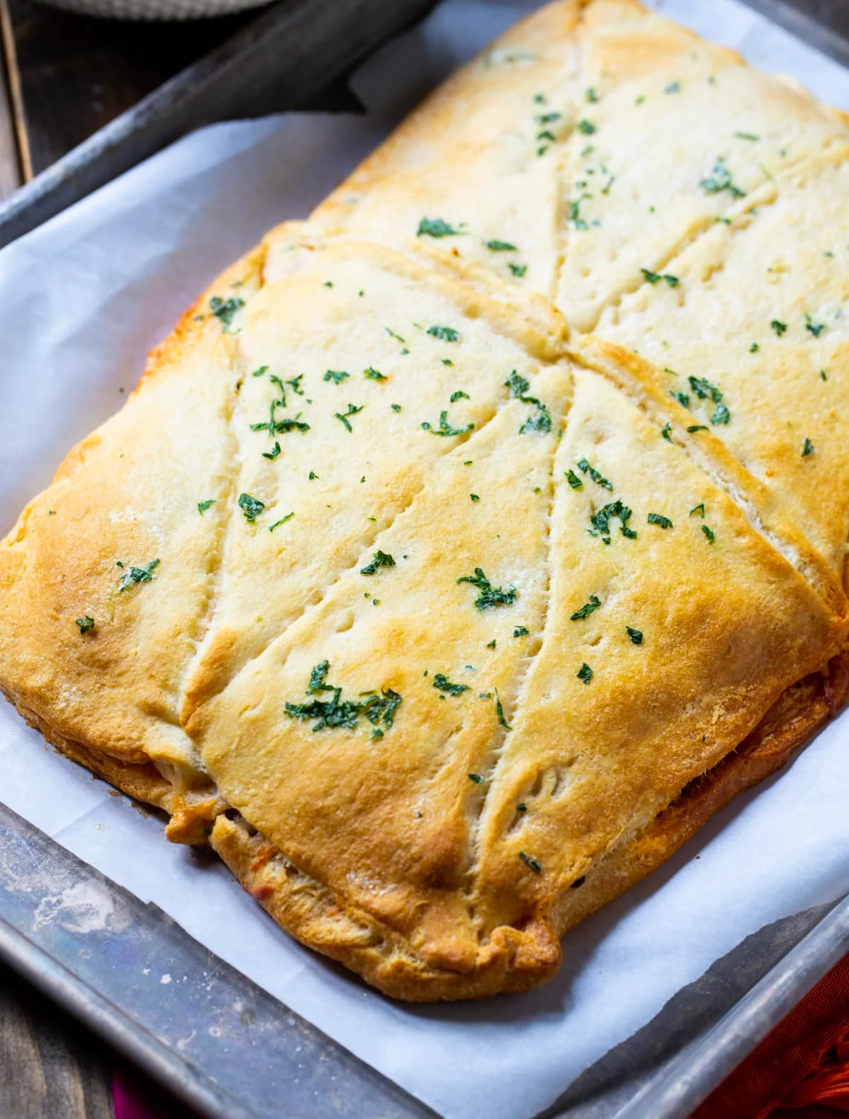 Whole baked lasagna on rimmed baking sheet.