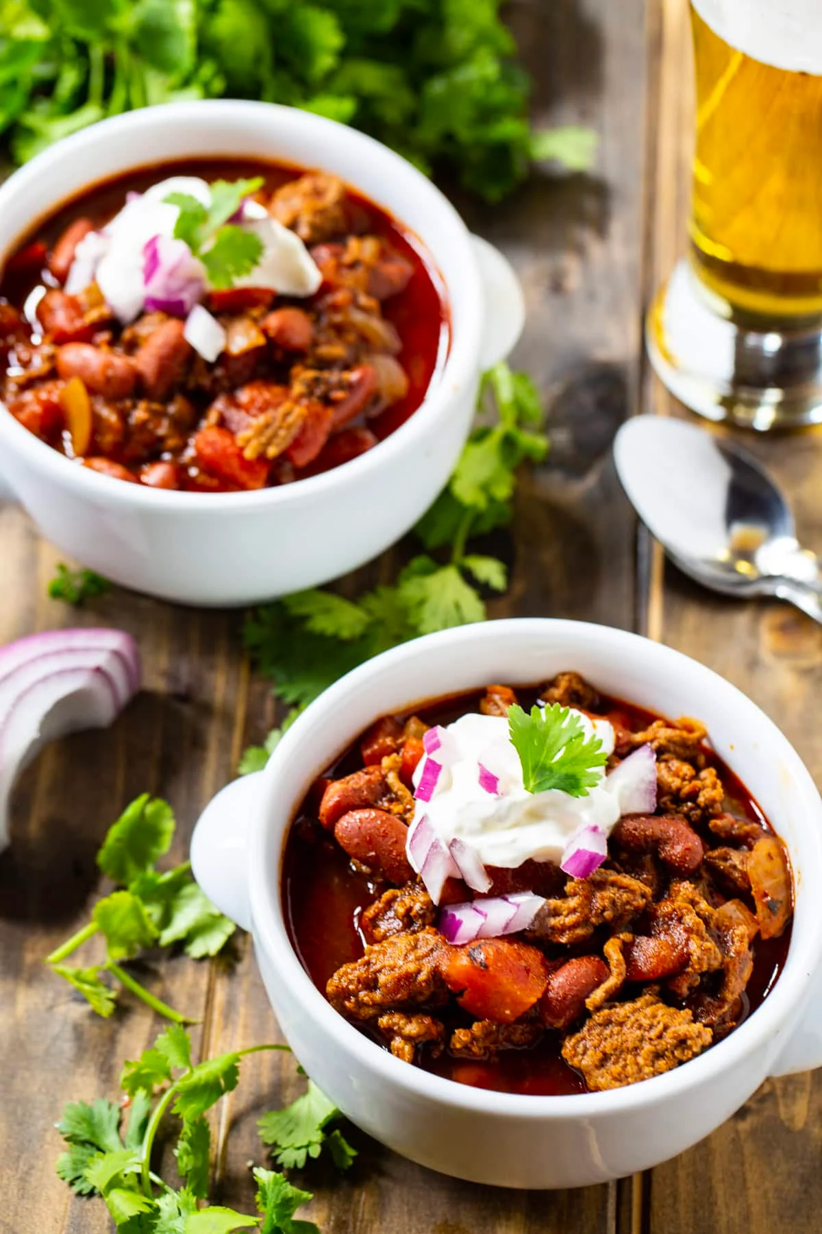 Dr Pepper Chili in 2 bowls and a glass full of beer.