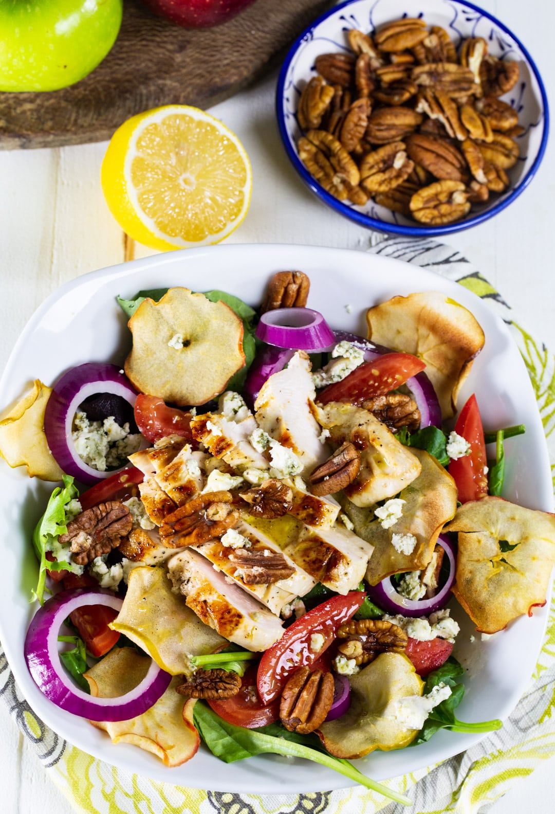 Salad in a bowl and a bowl full of pecans.