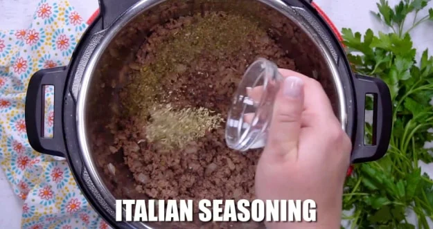 Adding Italian seasoning.