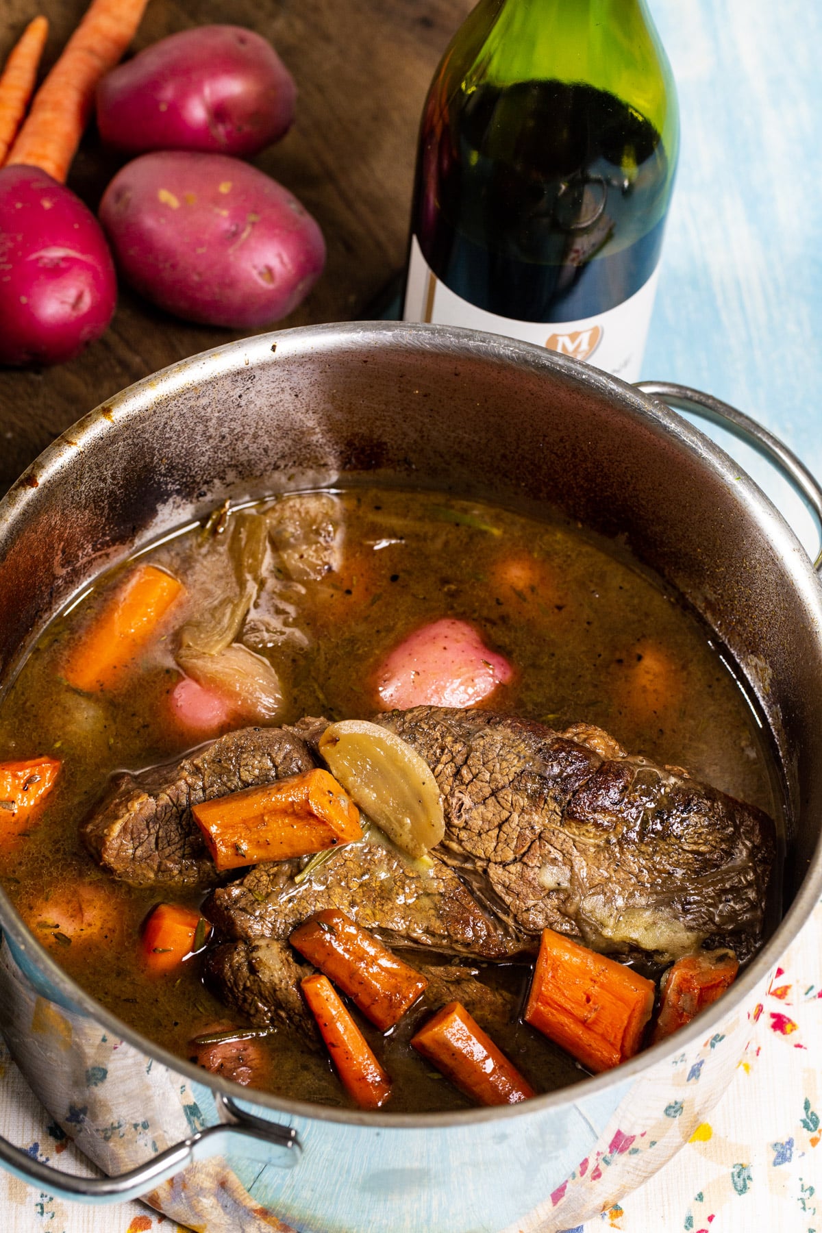 Finished dish in a Dutch oven and bottle of wine.