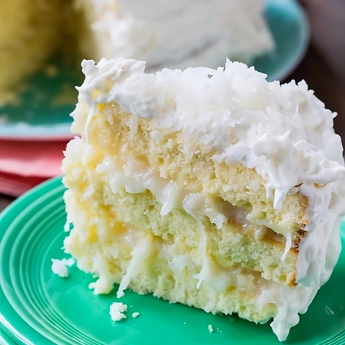 Slice of Coconut Celebration Cake on a plate.