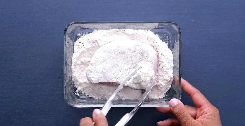 Coating pork chops in flour.
