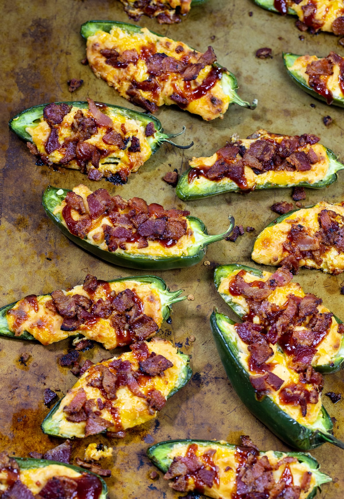 Stuffed and cooked jalapenos on baking sheet.