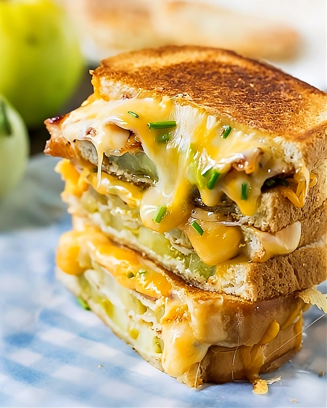 Sandwich cut in half with cheese dripping down.