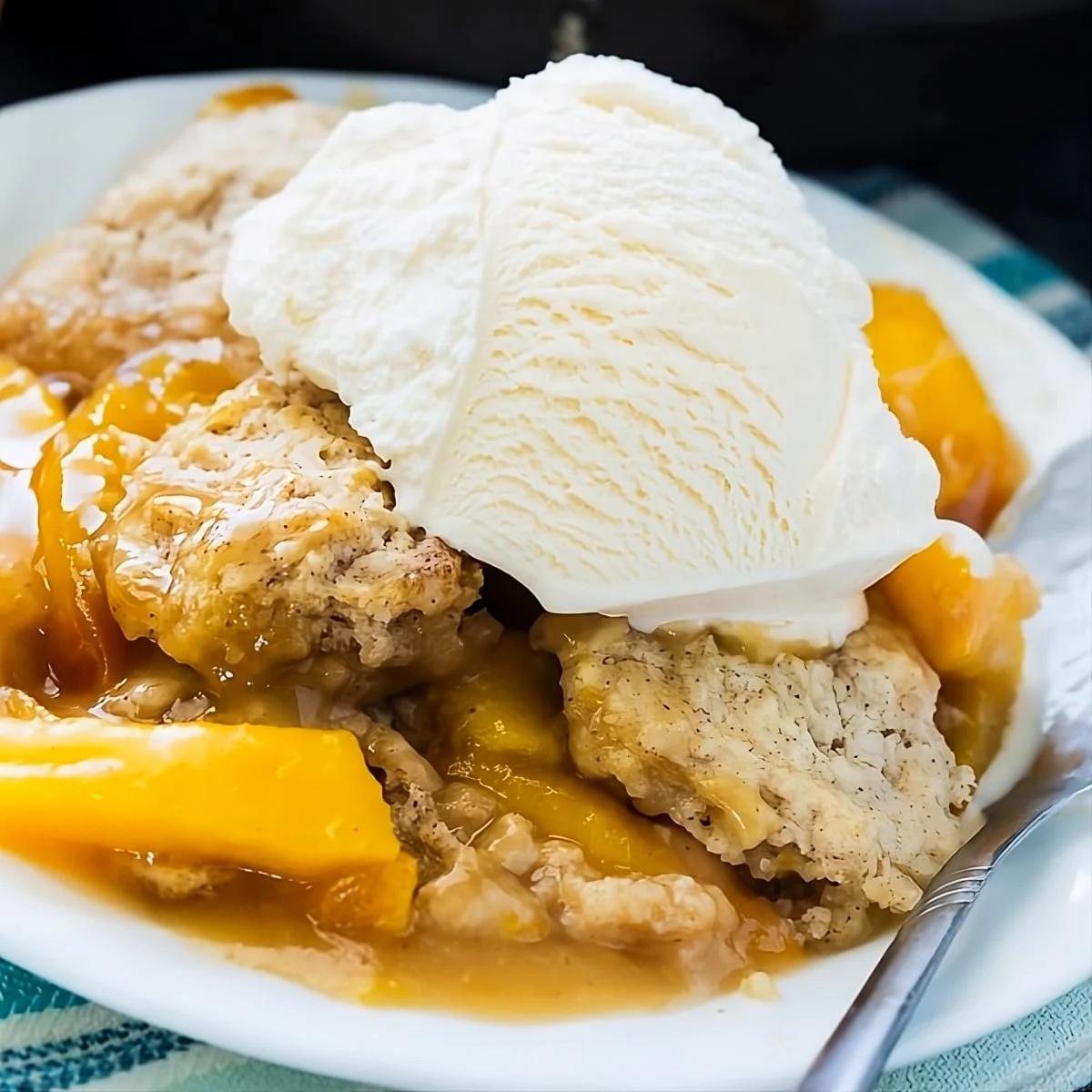 Skillet Bourbon Peach Cobbler topped with vanilla ice cream.