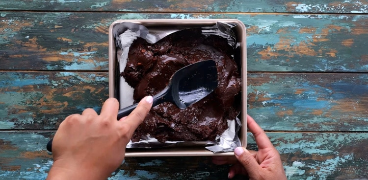 Spreading fudge mixture out in pan.