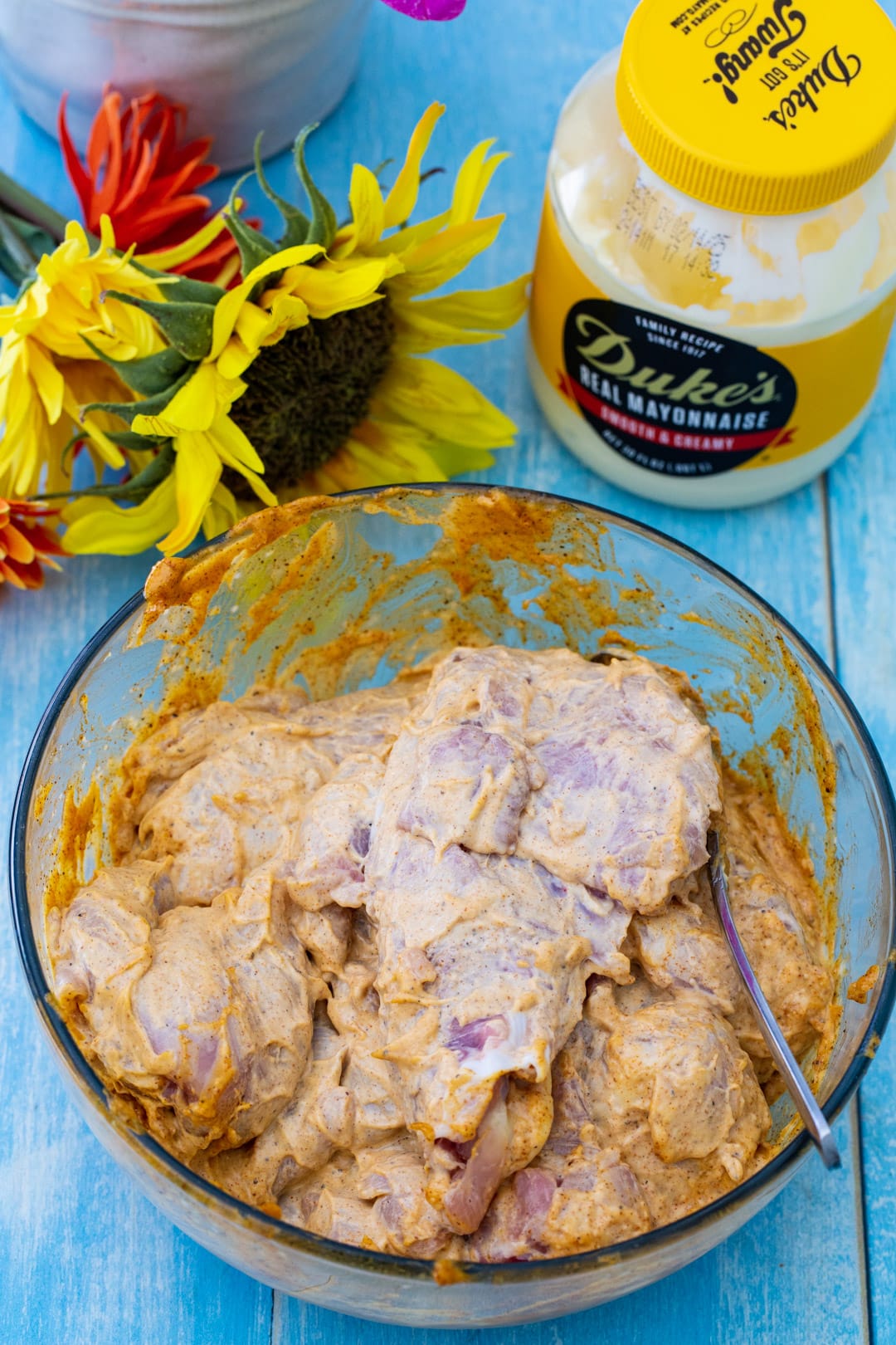 Raw chicken in a bowl with marinade.