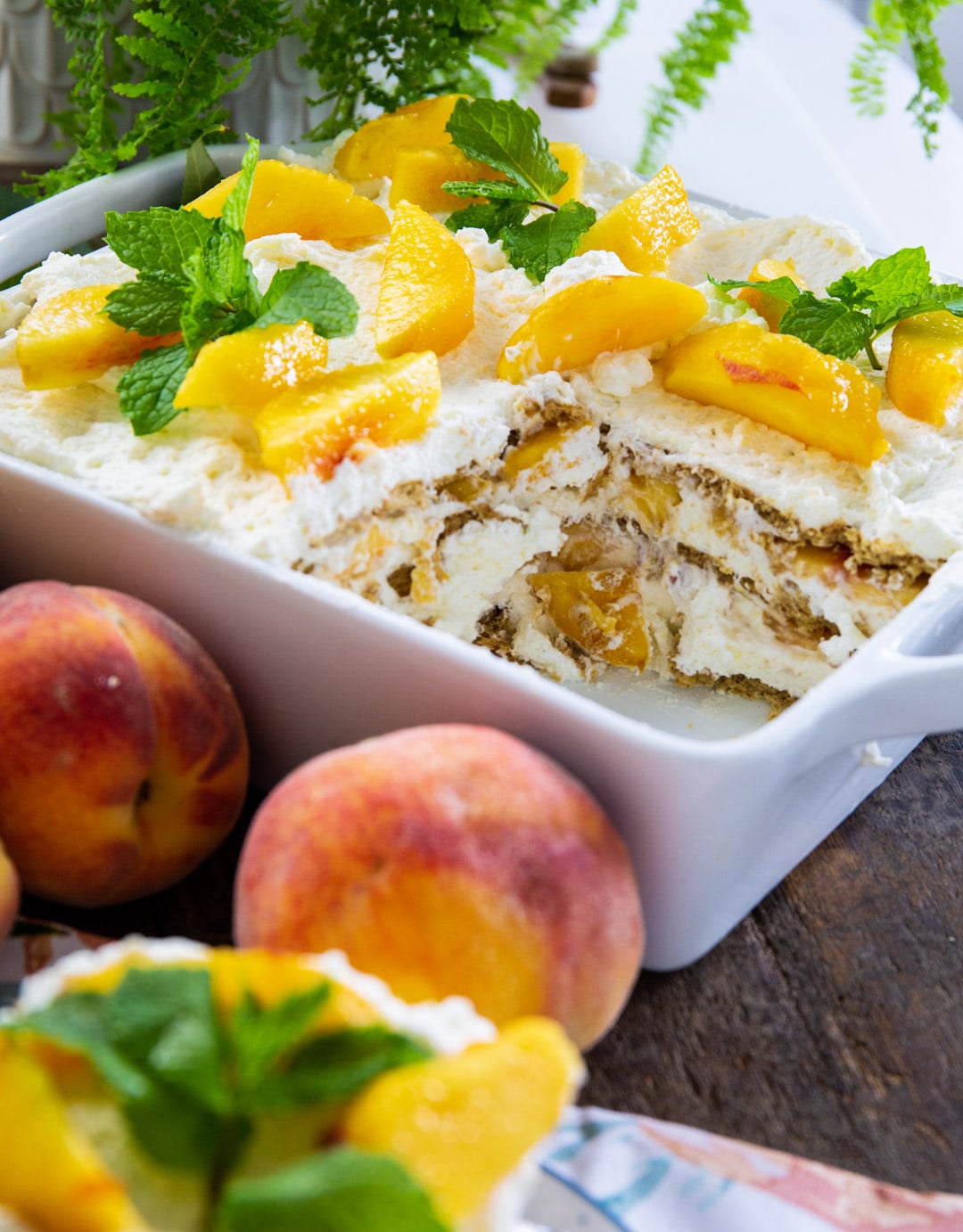 Peach Icebox Cake topped with fresh peach slices and mint sprigs.