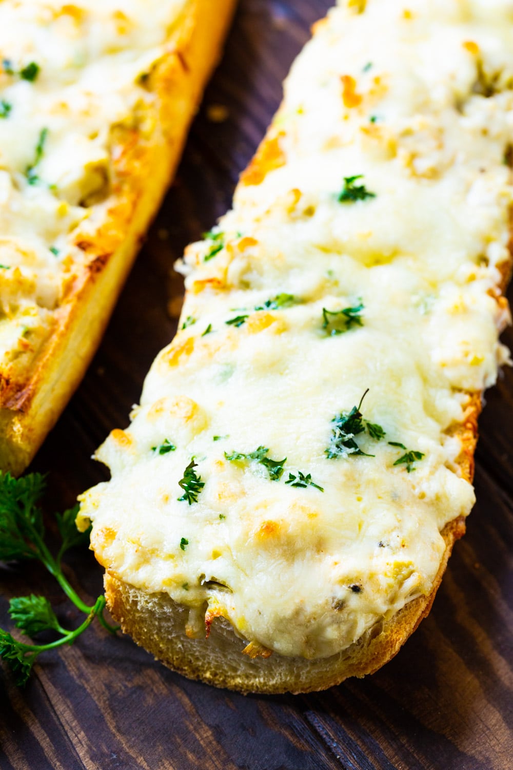 Long loaf of French bread topped with artichoke crab mixture.