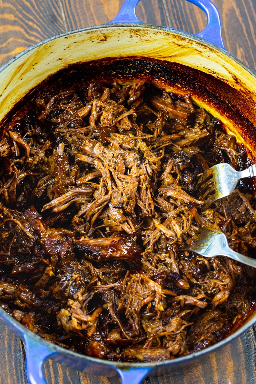 Shredding beef with 2 forks.