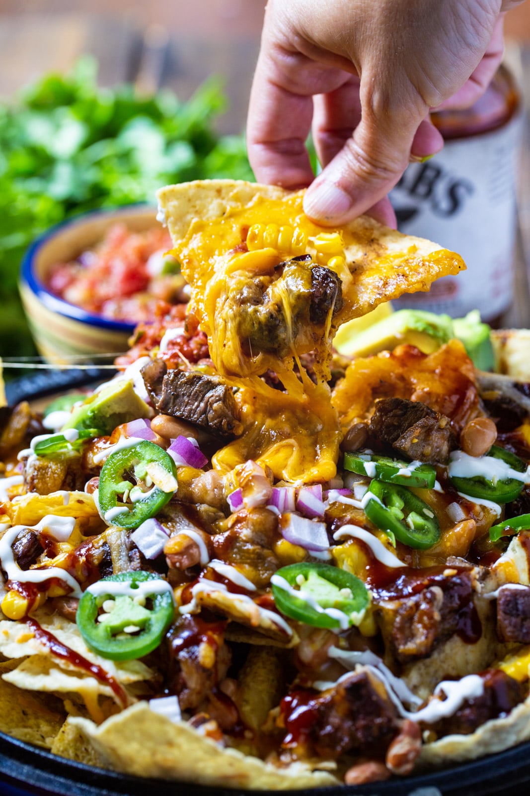 Hand picking up a nacho.