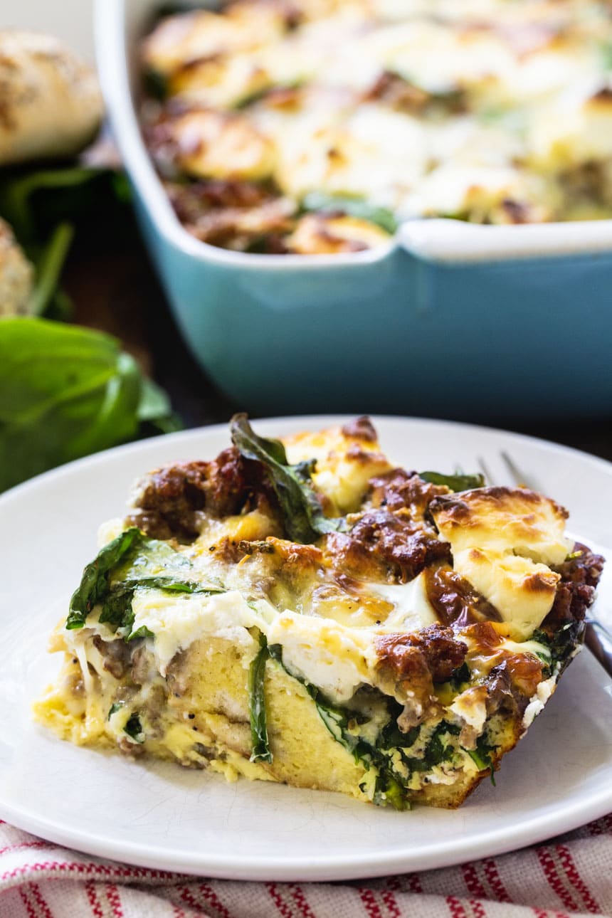 Slice of breakfast casserole on a plate with baking dish in background.