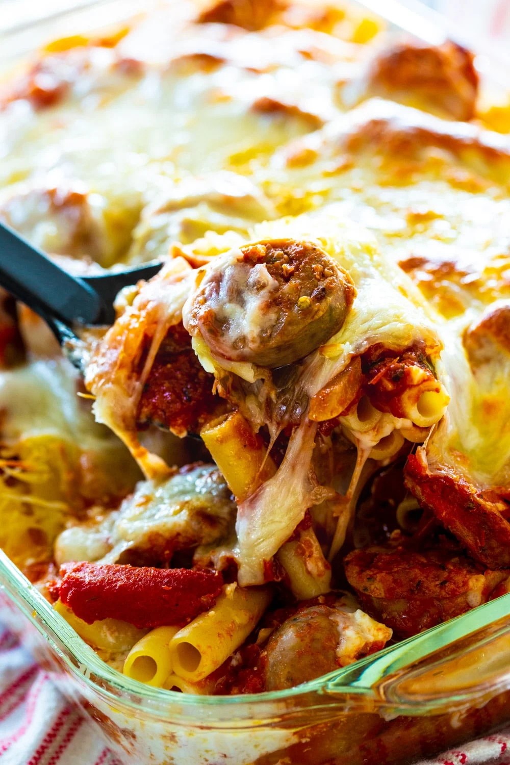 Spoon scooping up Baked Ziti with Italian Sausage.