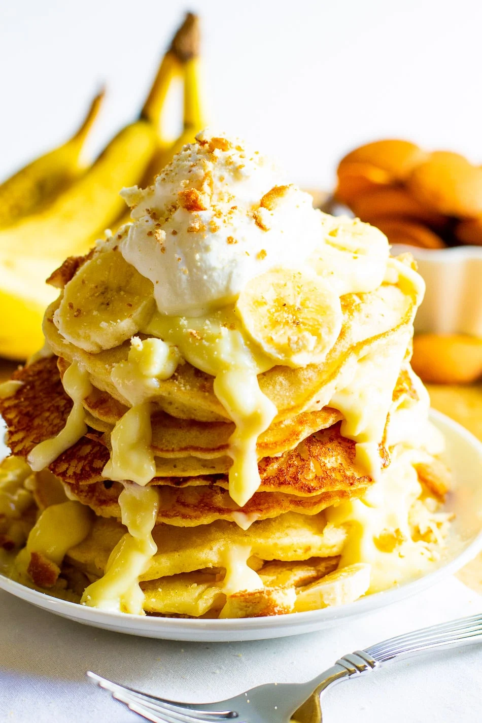 Stack of pancakes topped with whipped cream.