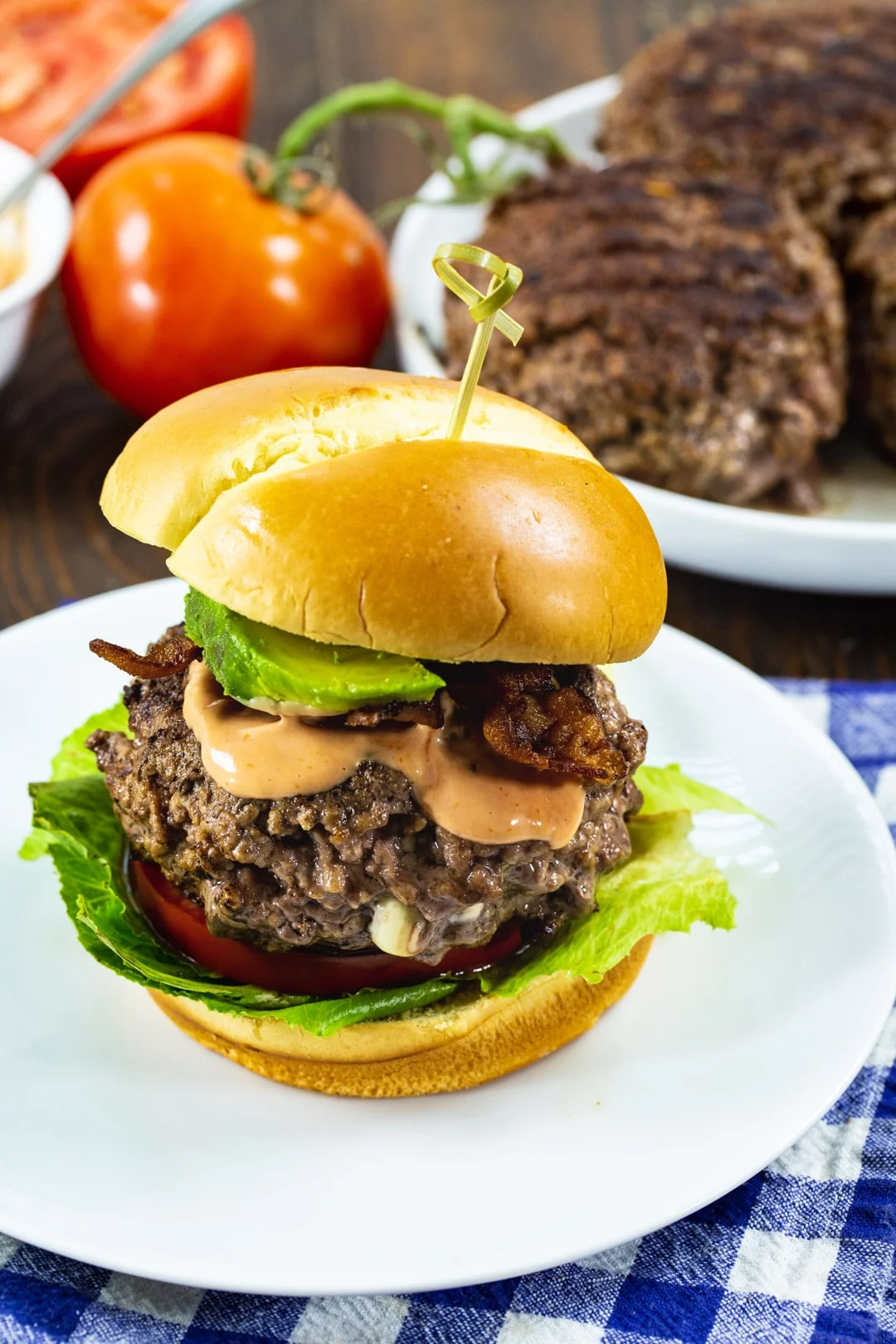 Burger on a bun and plate with burgers.
