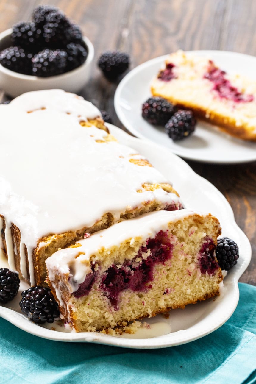 Blackberry Buttermilk Loaf Cake with fresh blackberries in background