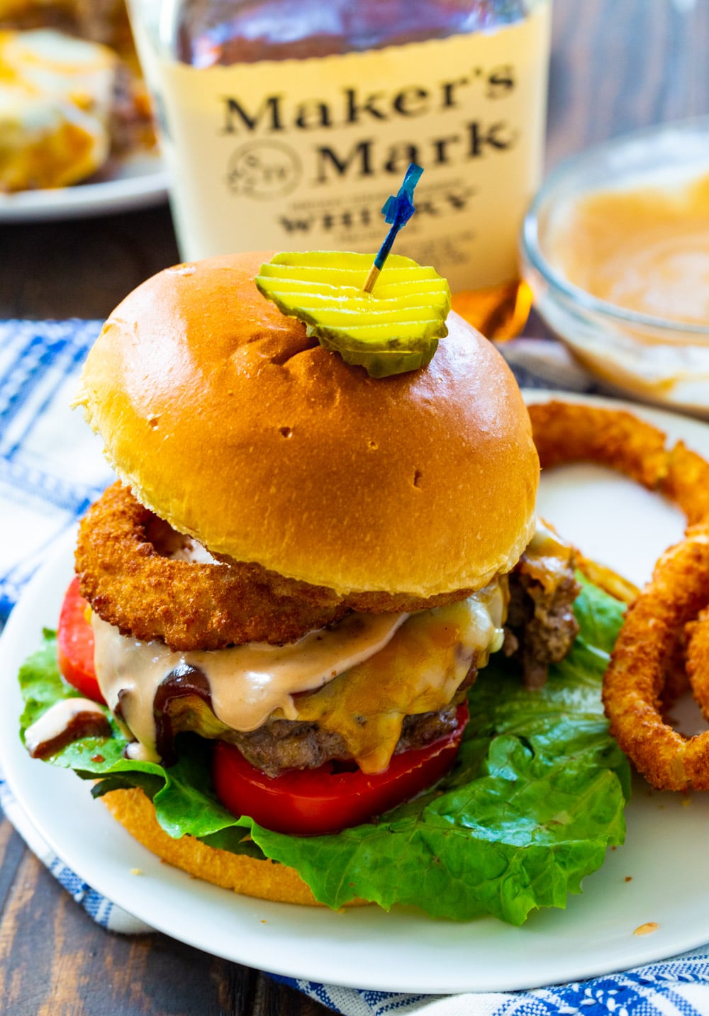 Bourbon BBQ Burger dished up on a plate with fried onion rings.