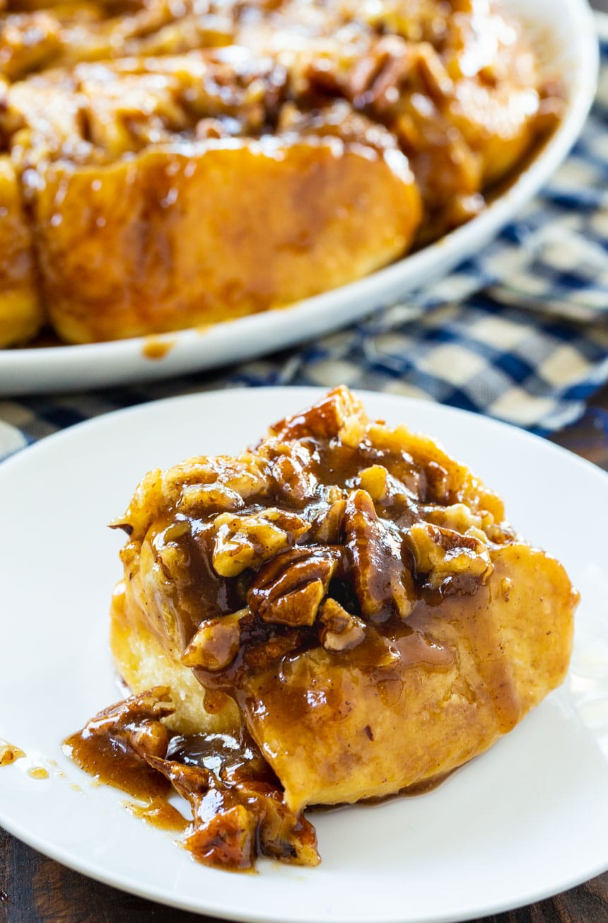 A Bourbon Pecan Cinnamon Roll on a small white plate