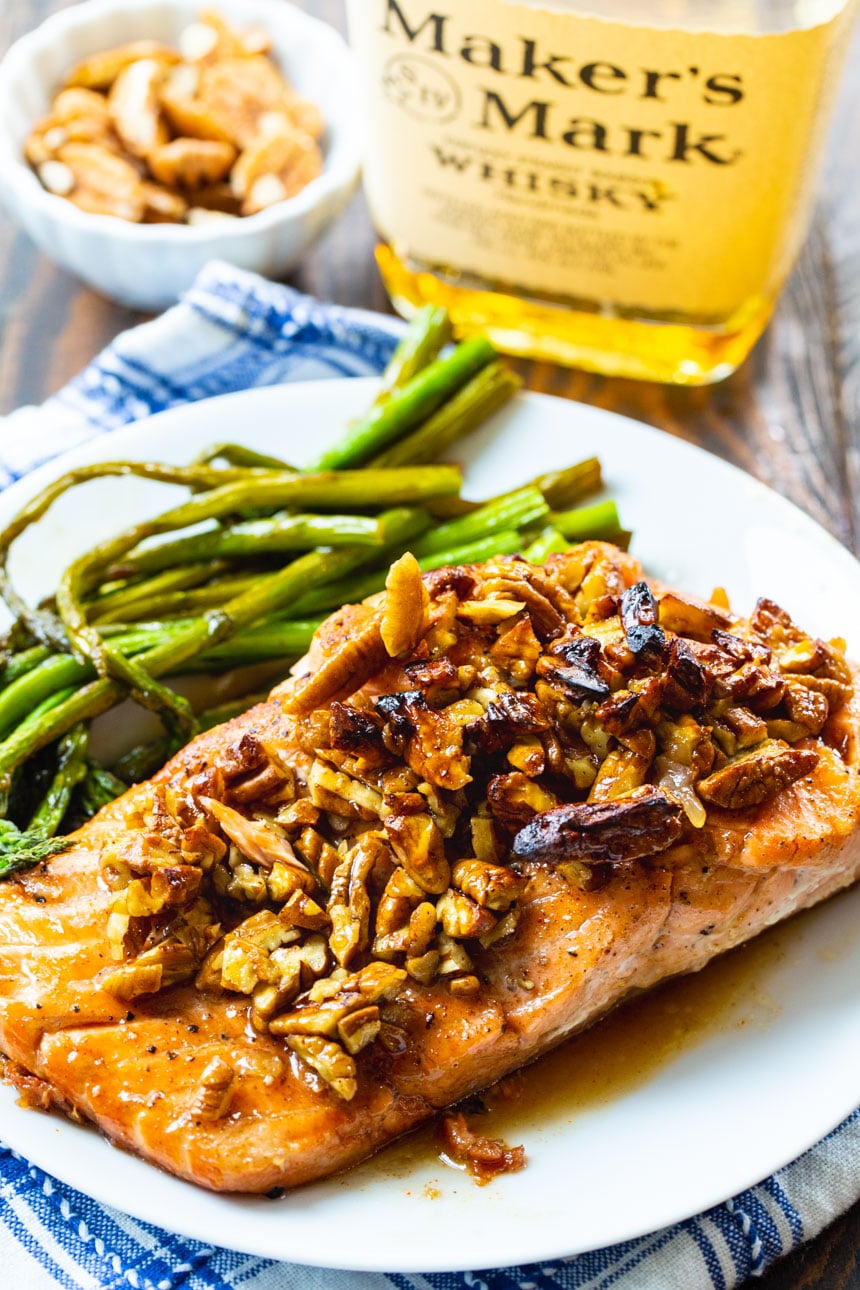 Salmon fillets with bourbon-pecan glaze on a white plate with asparagus