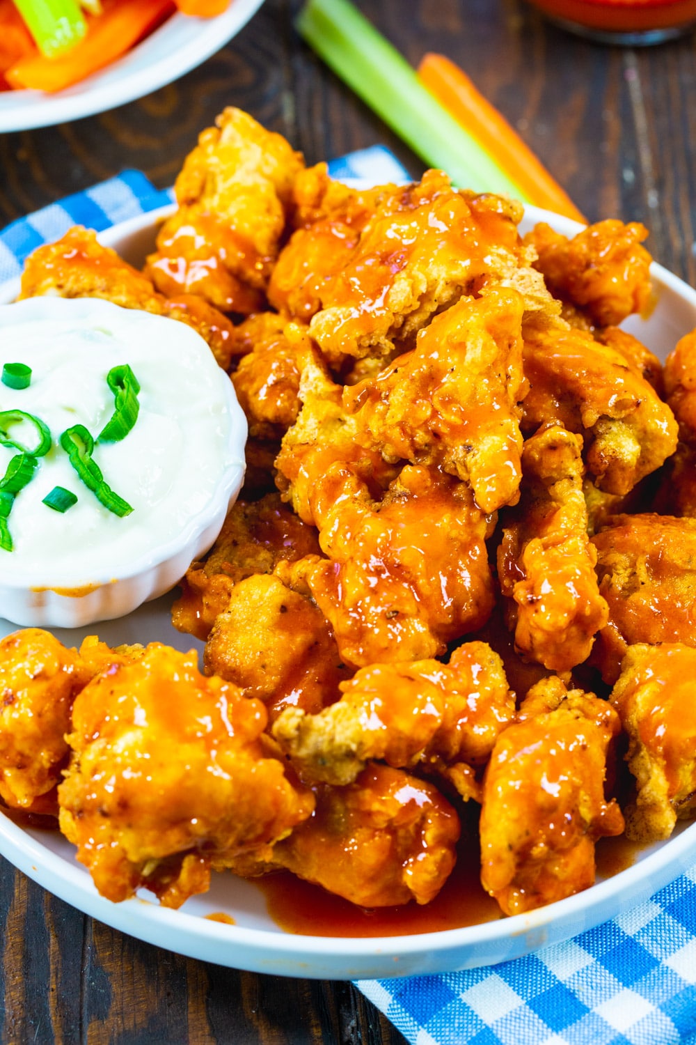 Chicken Nuggets coated in buffalo sauce on a plate.