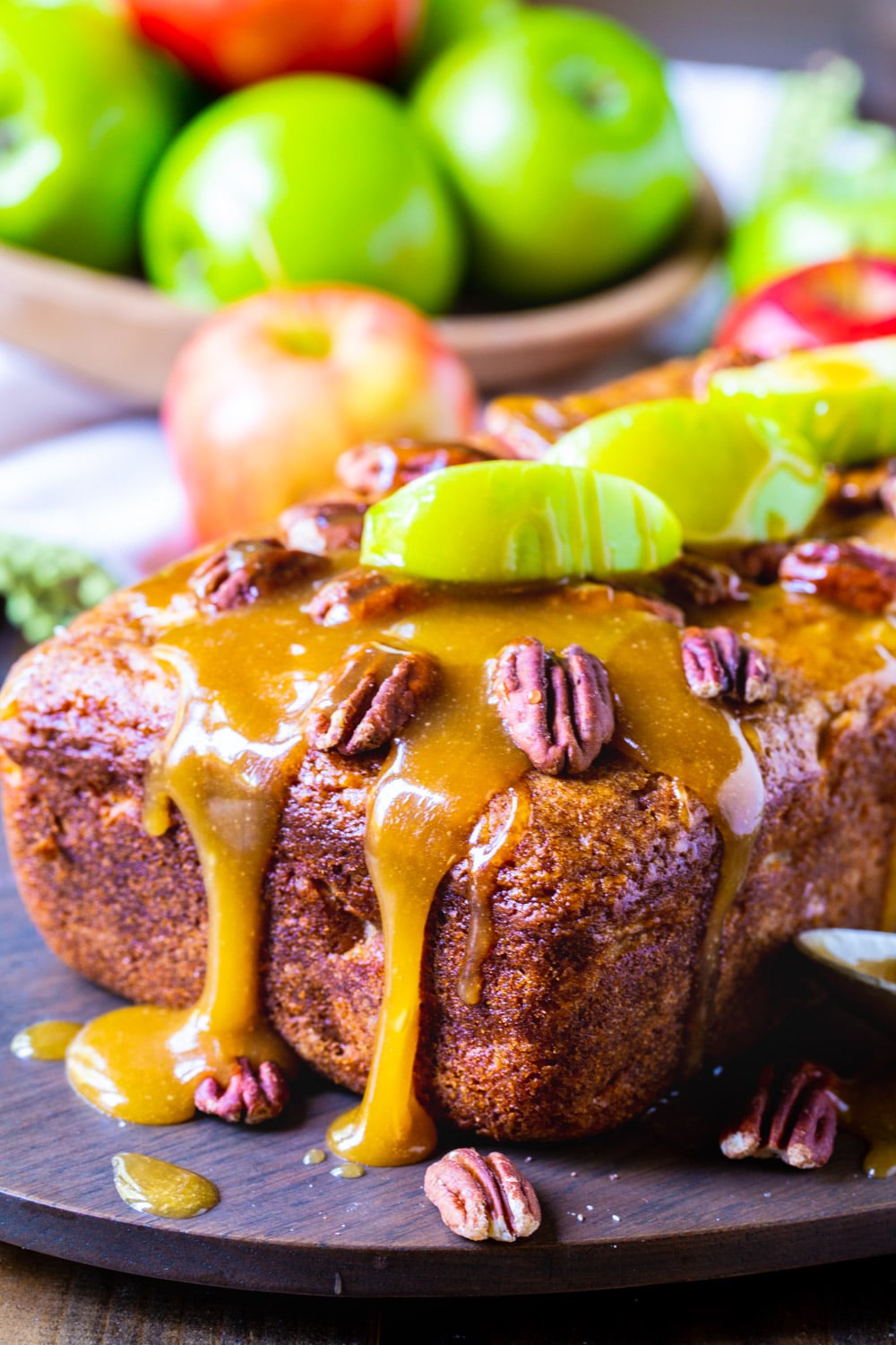 Loaf of Caramel Apple Bread with bowl of apples.