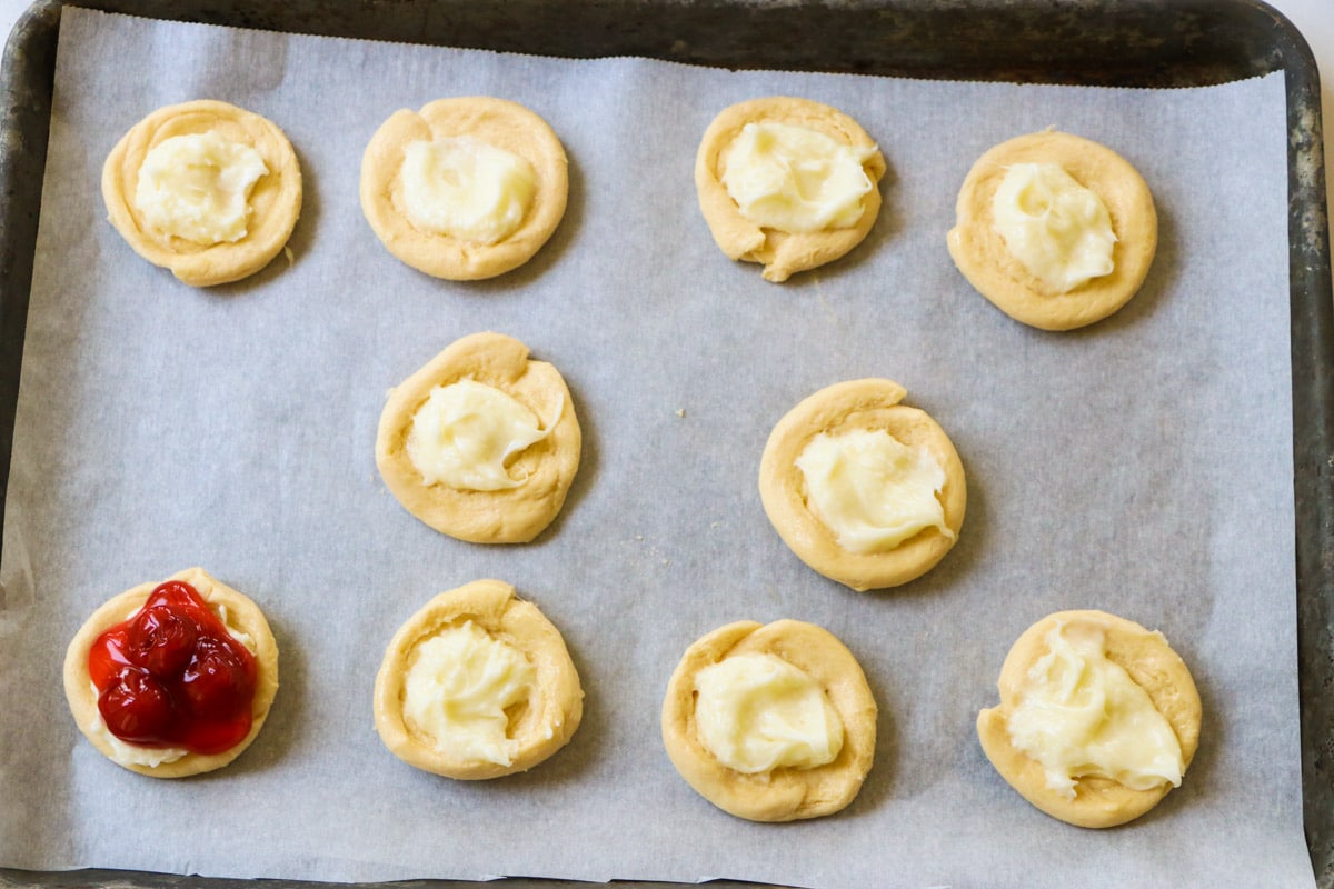 Unbaked danishes on baking sheet.