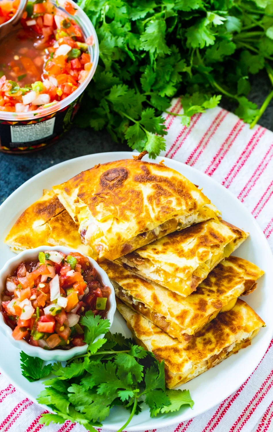 Quesadilla triangles on plate with bowl of pico de gallo.