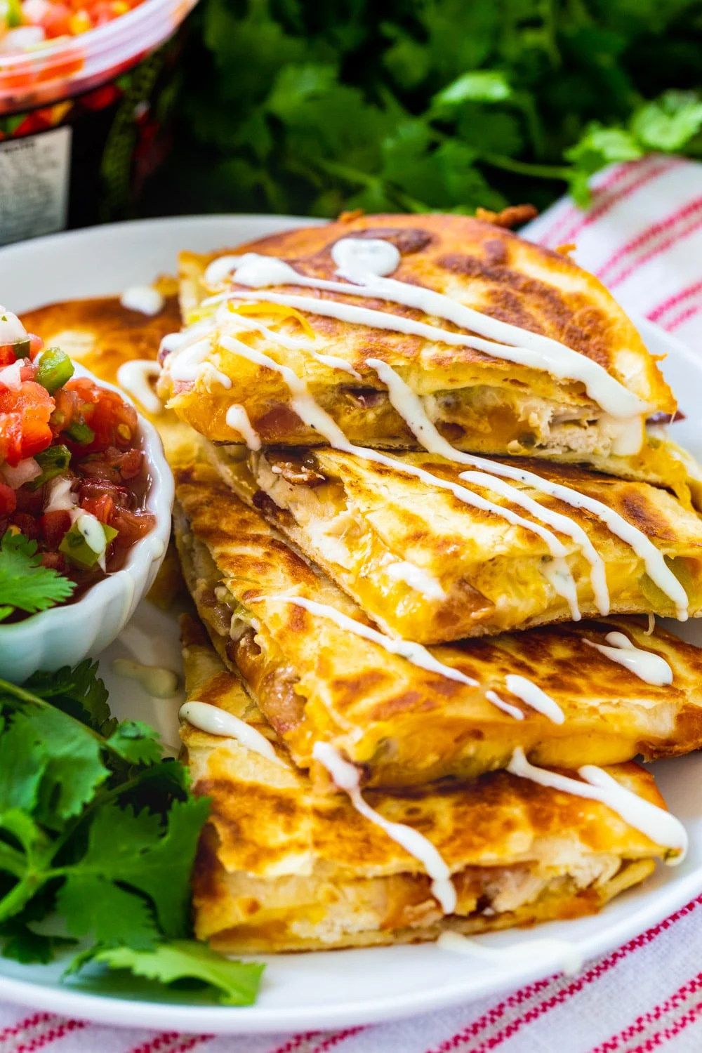 Chicken, Bacon and Ranch Quesadillas drizzle with ranch on a plate.