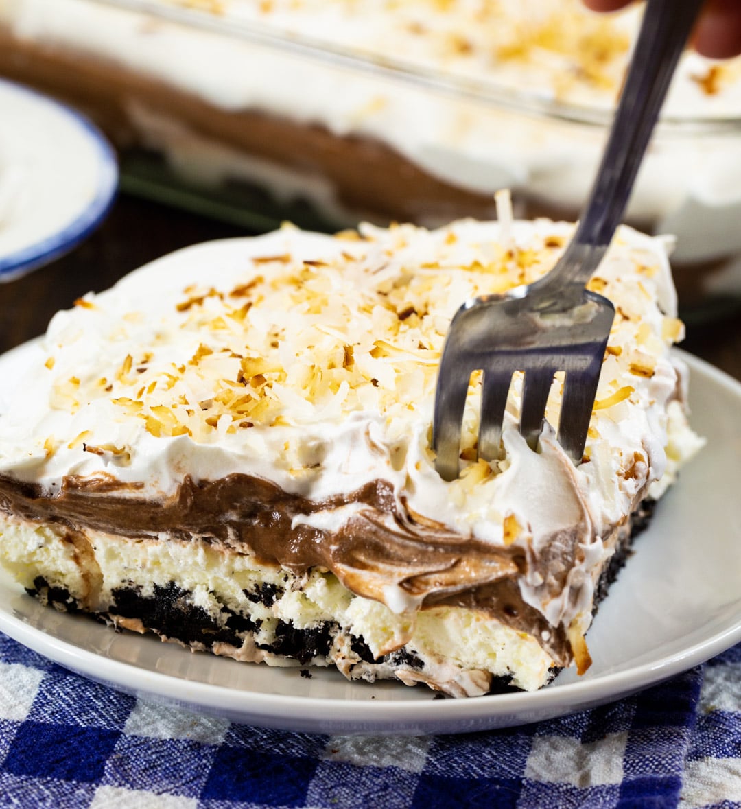 Fork being stuck in slice of Chocolate Coconut Lush.