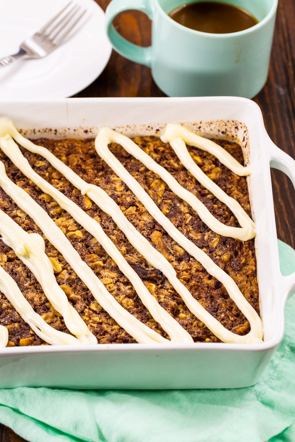 Baked Oatmeal topped with cream cheese glaze in a baking dish.
