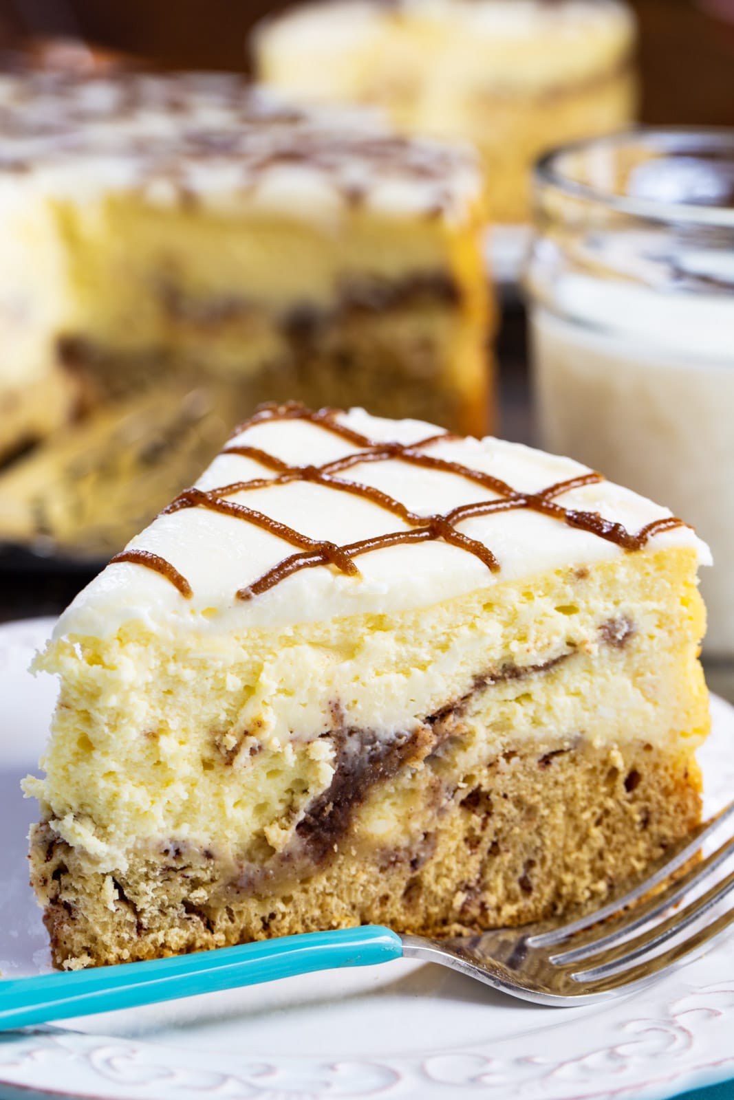 Slice of Cinnamon Roll Cheesecake on a plate with a fork.