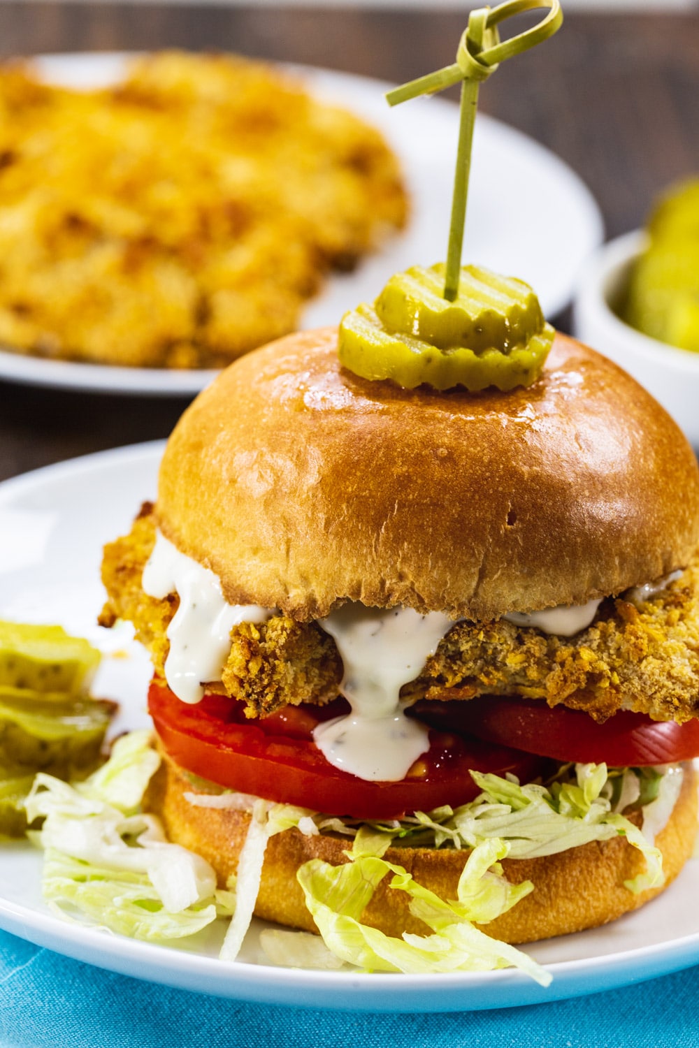 Close-up of Cornflake Crusted Chicken Sandwich with ranch dressing drippinf down.