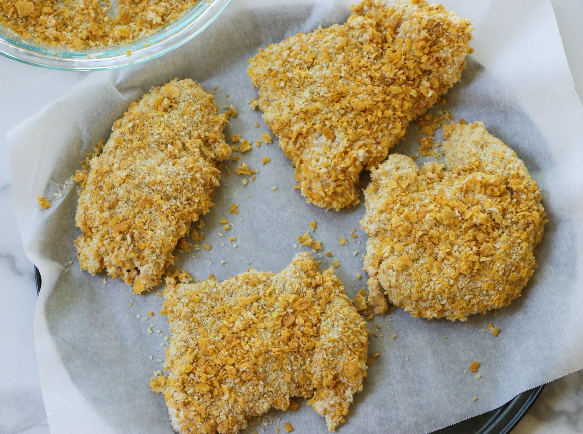 Uncooked chicken coated in cornflakes.