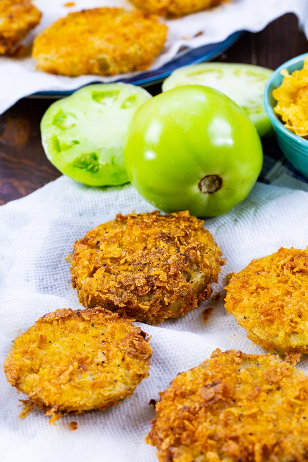 Fried green tomato slices on paper towels.
