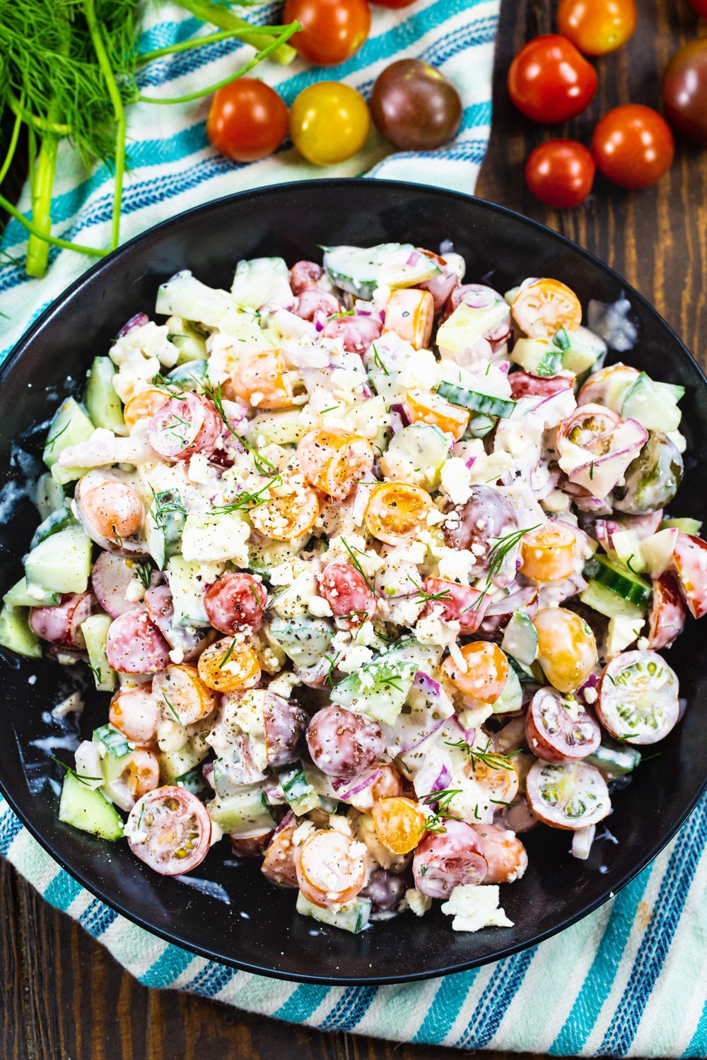 Tomato and Cucumber Salad with cherry tomatoes surrounding bowl.