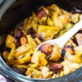 Crock Pot Cabbage and Kielbasa in black slow cooker.