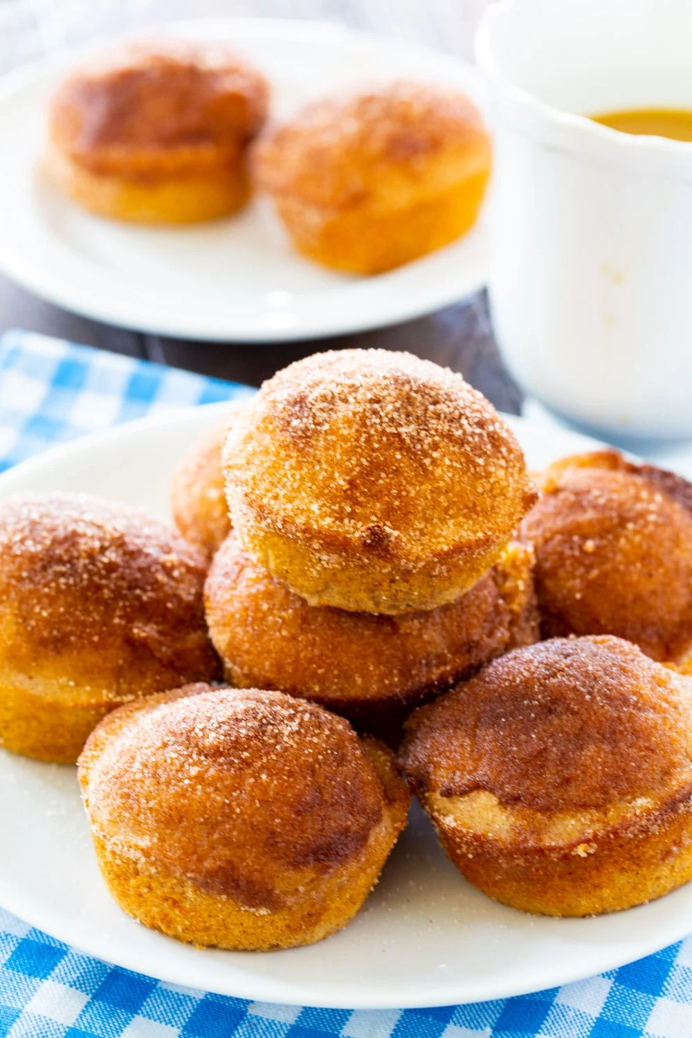 Muffins on a plate with a cup of coffee.