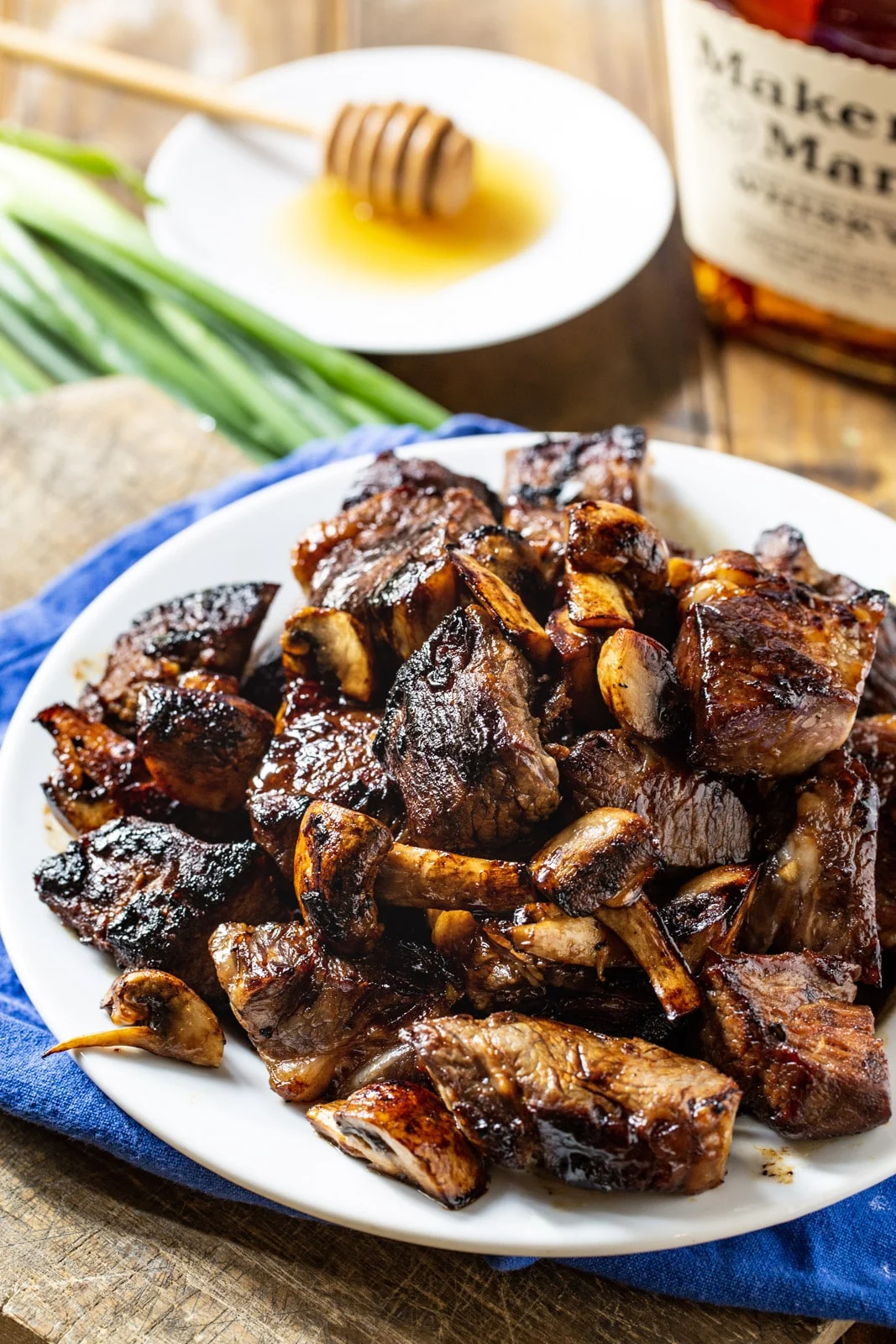 Steak Tips on plate and bottle of bourbon.