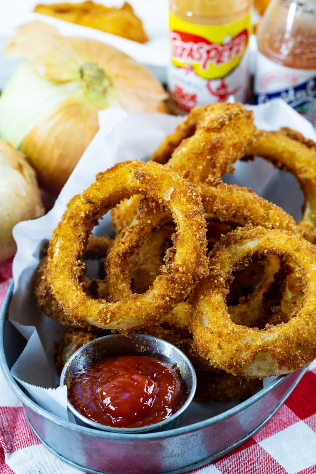 Hot Sauce Marinated Onion Rings in a serving dish with ketchup.