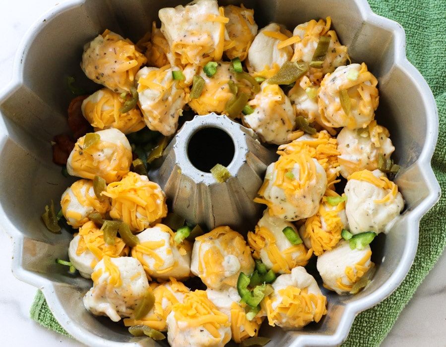 Biscuit balls coated in cheese in bundt pan.