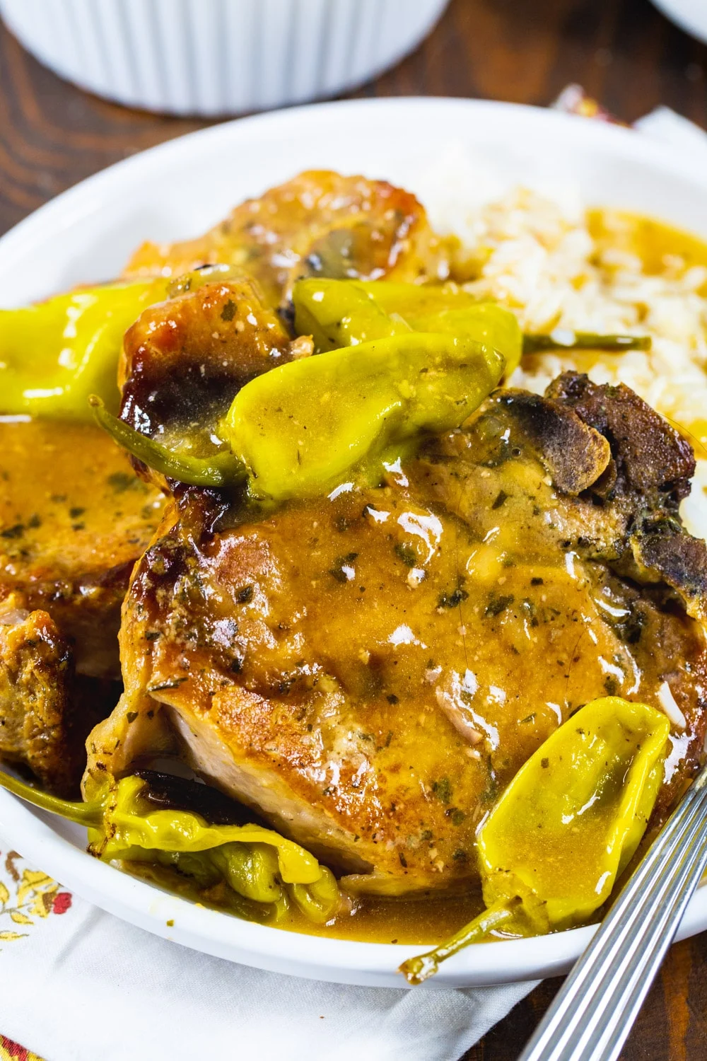 Pork chops with pepperoncini peppers on a plate.