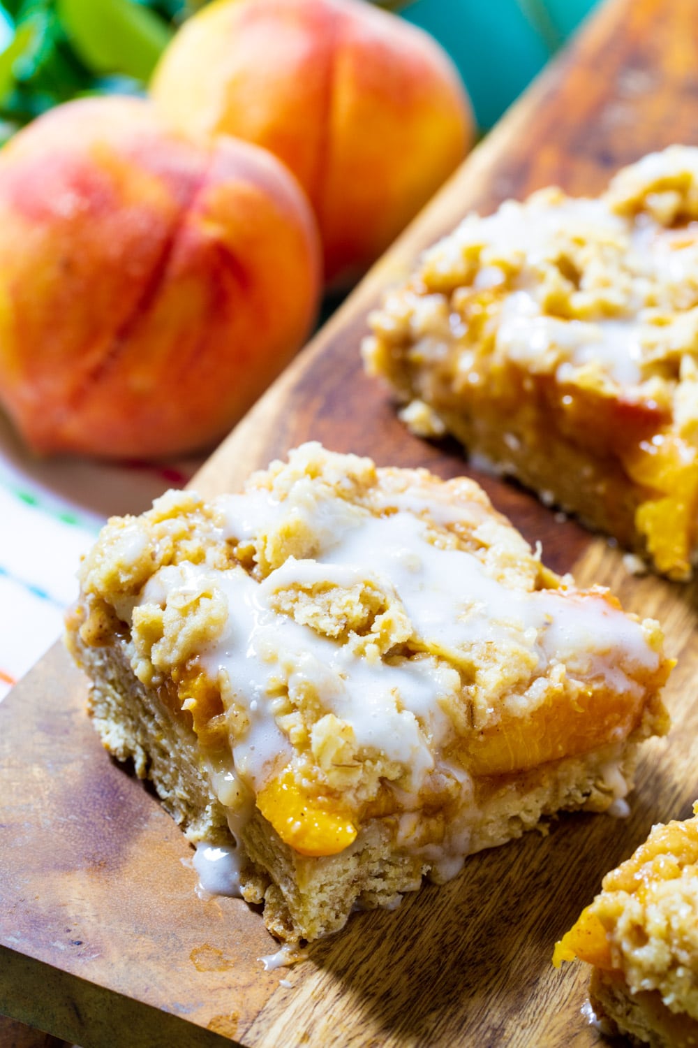 Peach Cobbler Bars covered with glaze on a wodden board.