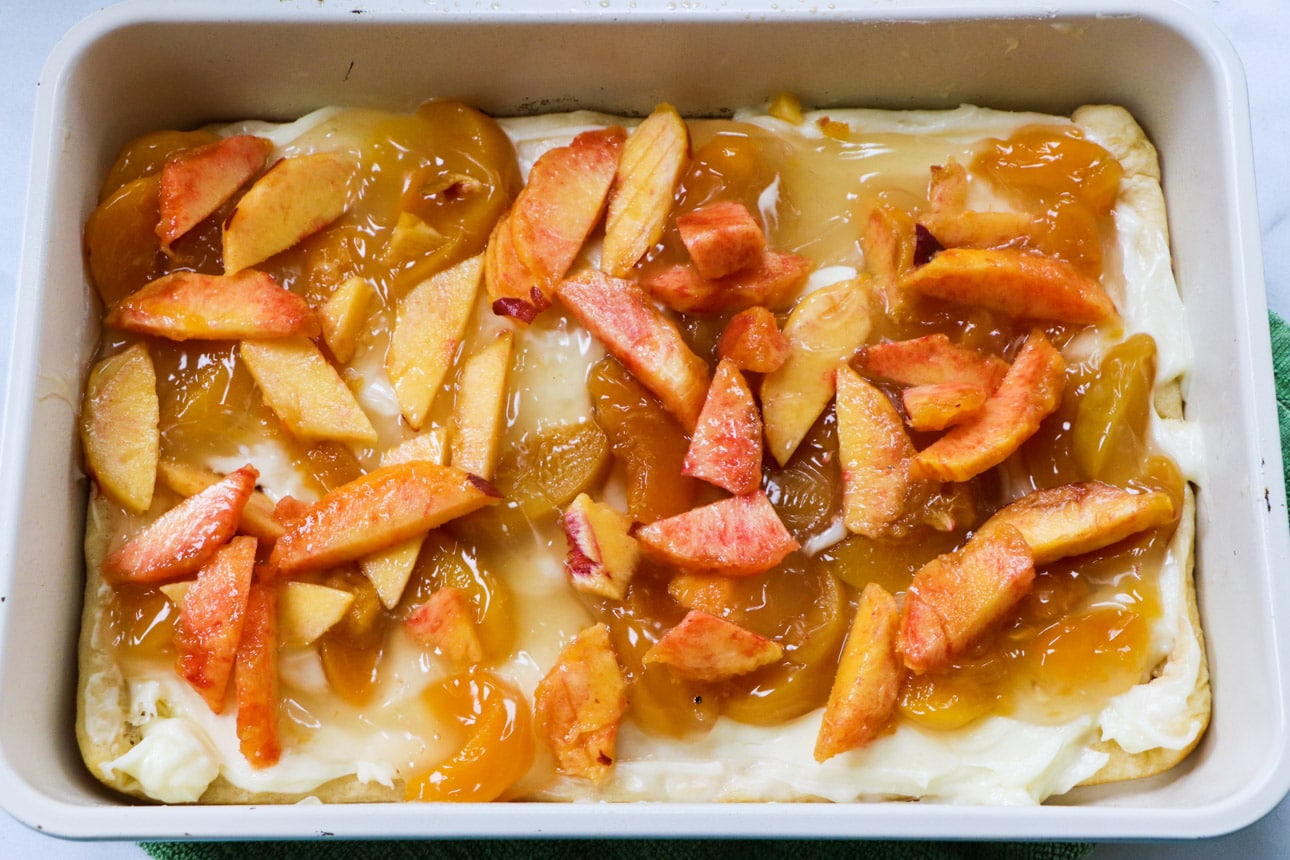 Peaches on top of crescent roll dough.