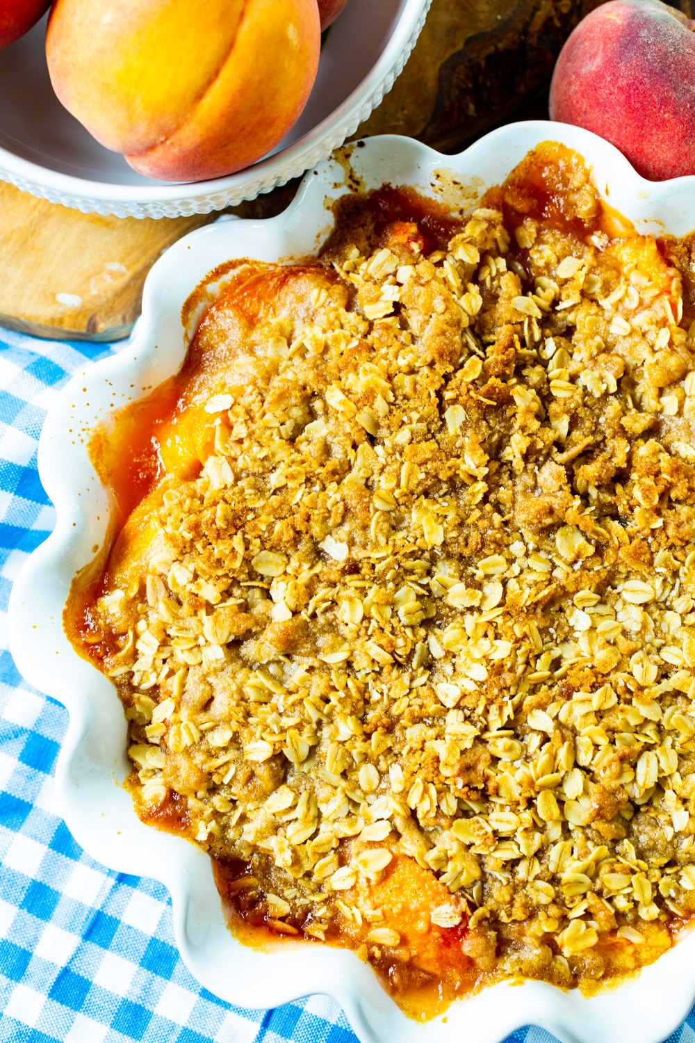 Overhead of crisp with peaches in a white pie plate.