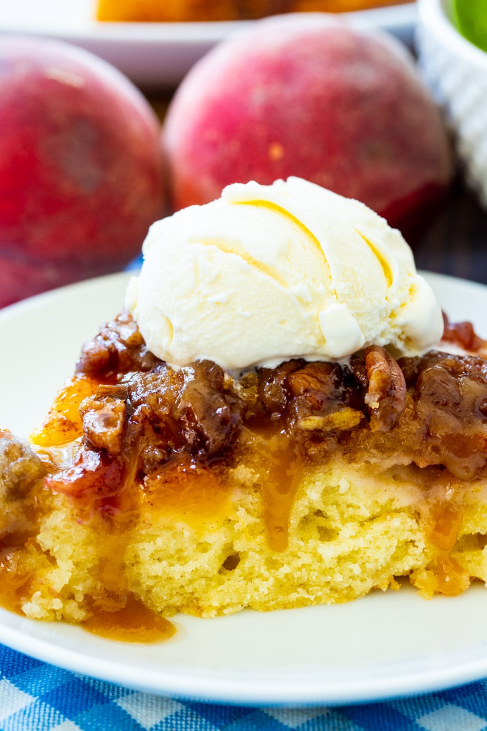 Close-up of slice of Peach Praline Upside Down Cake topped with vanilla ice cream.