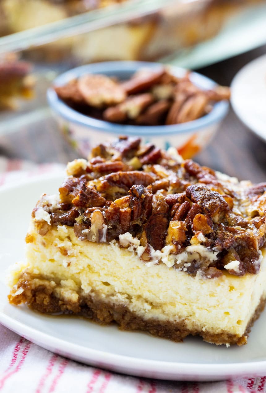 Cheesecake Bar on plate with bowl of pecans in background.
