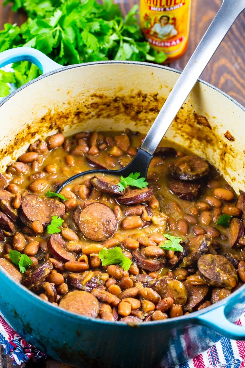Spoon scooping up Pintos and Sausage.